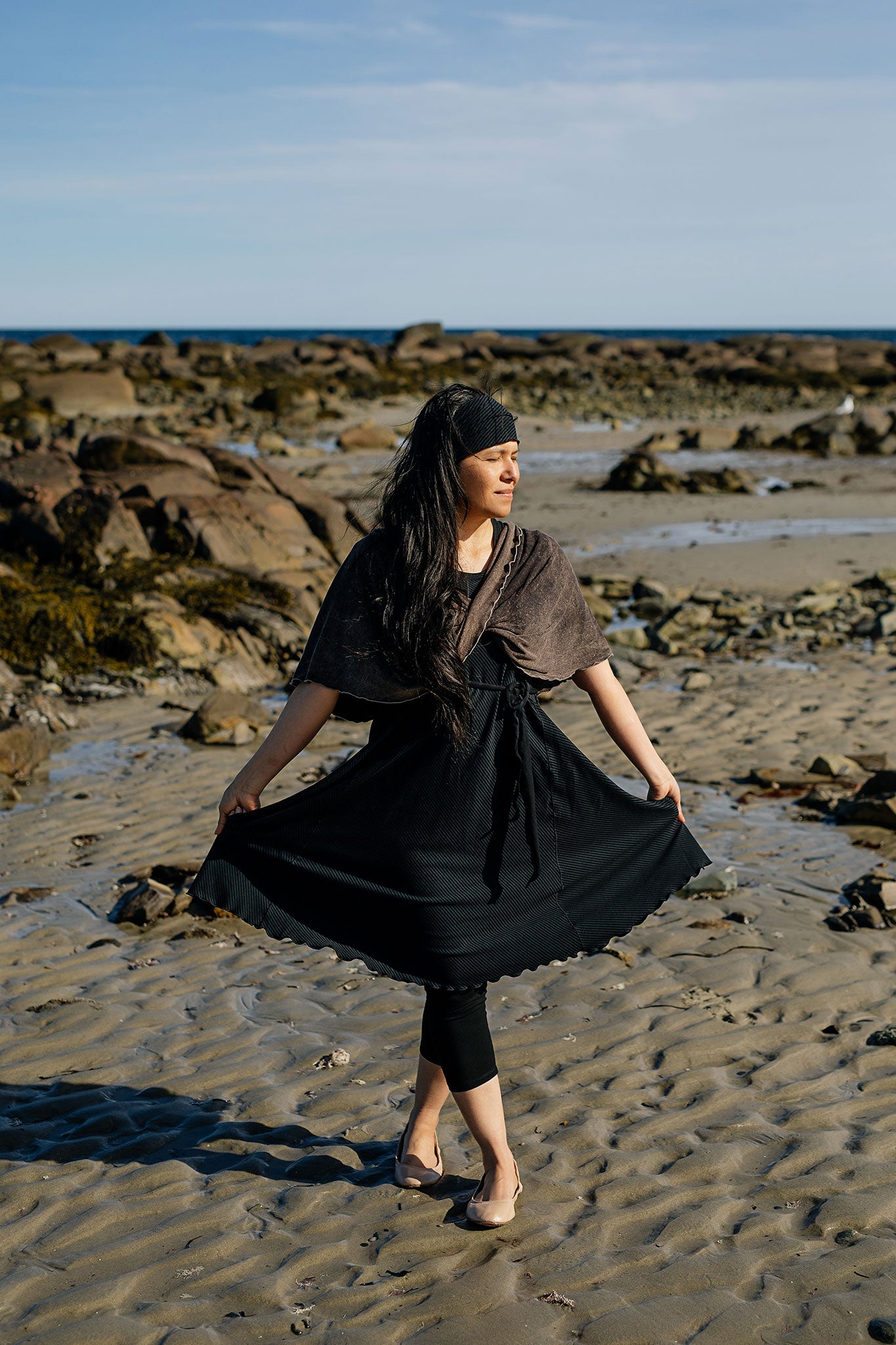 glow dress in subtle black with loop in warm mineral worn as a shawl