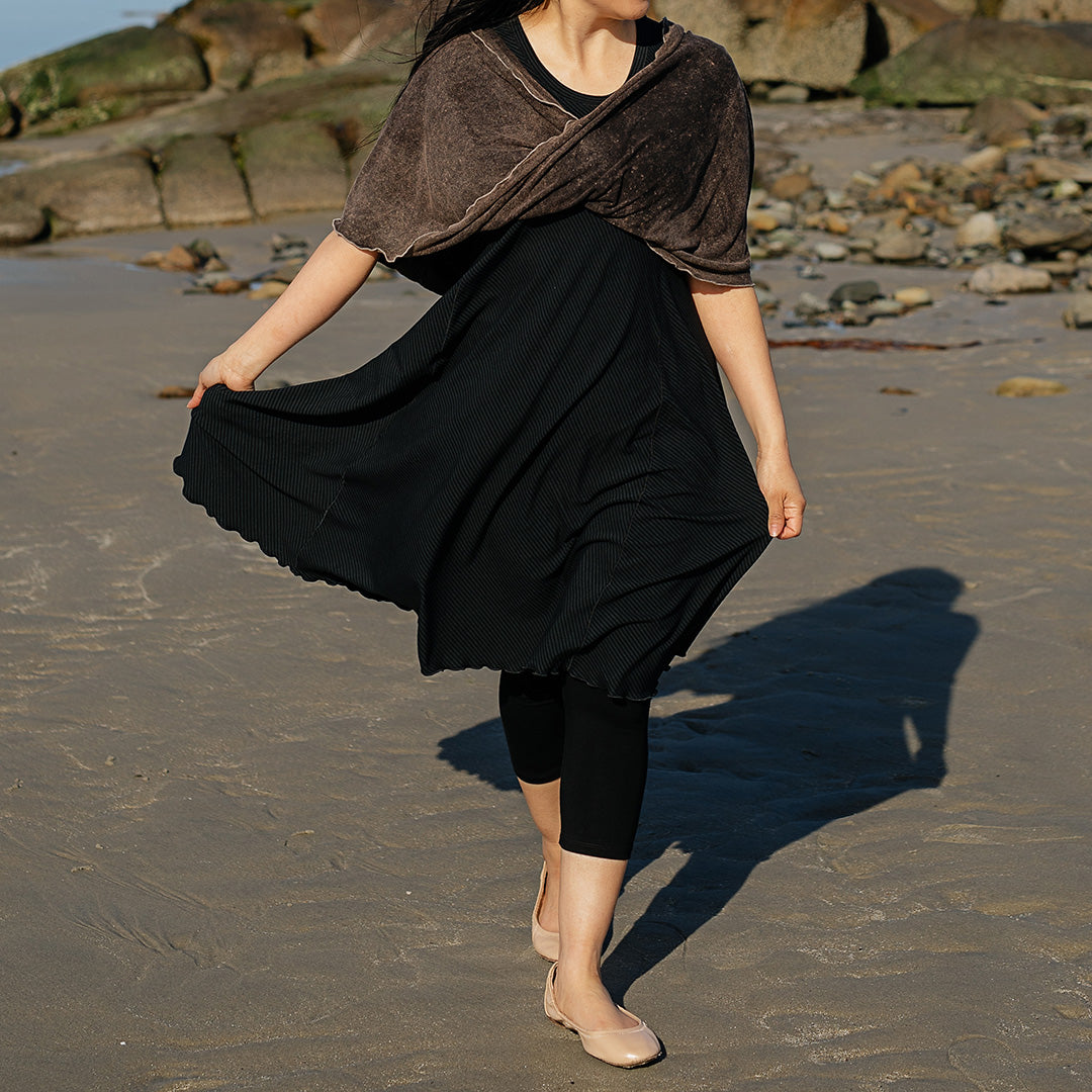 glow dress in subtle black with loop in warm mineral worn as a shawl