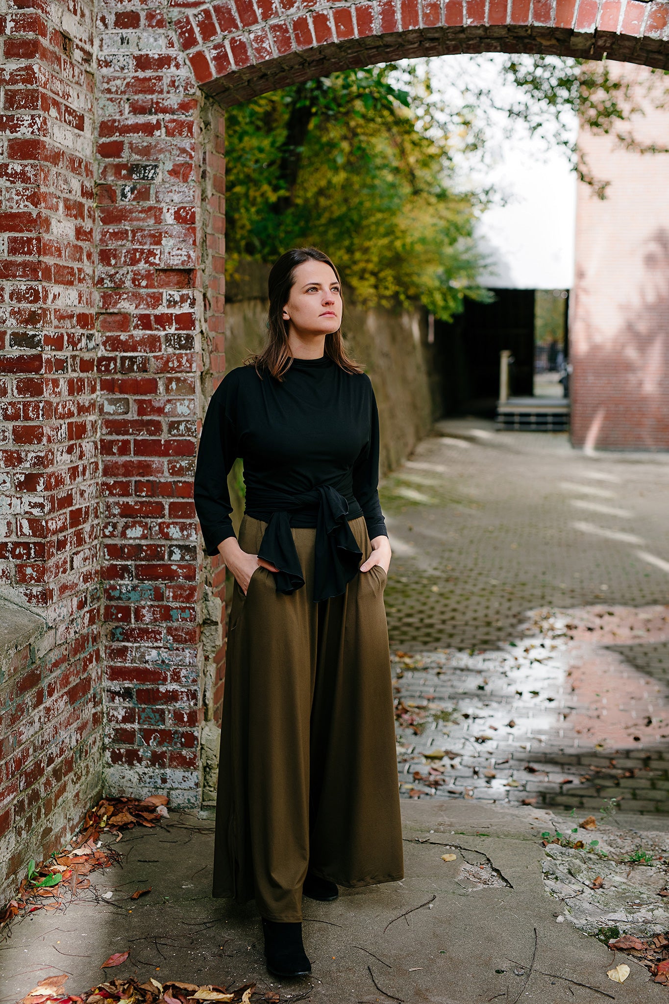 prima wrap jacket in black worn backwards and tied in the front over olive farmer