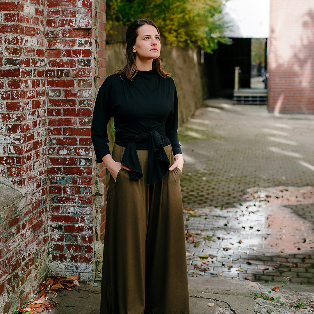 prima wrap jacket in black worn backwards and tied in the front over olive farmer