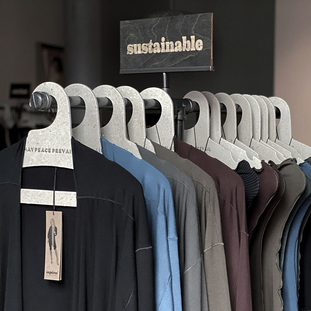 Perchas de cartón reciclado con la palabra paz