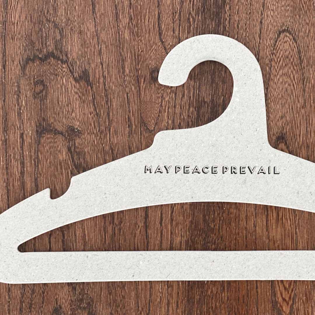 Perchas de cartón reciclado con la palabra paz