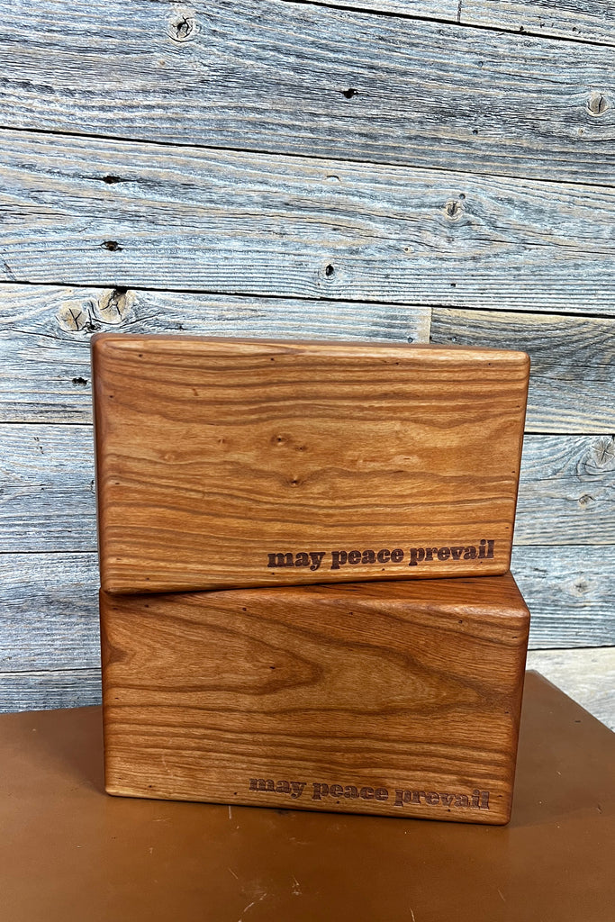 cherry wood yoga block with saying may peace prevail