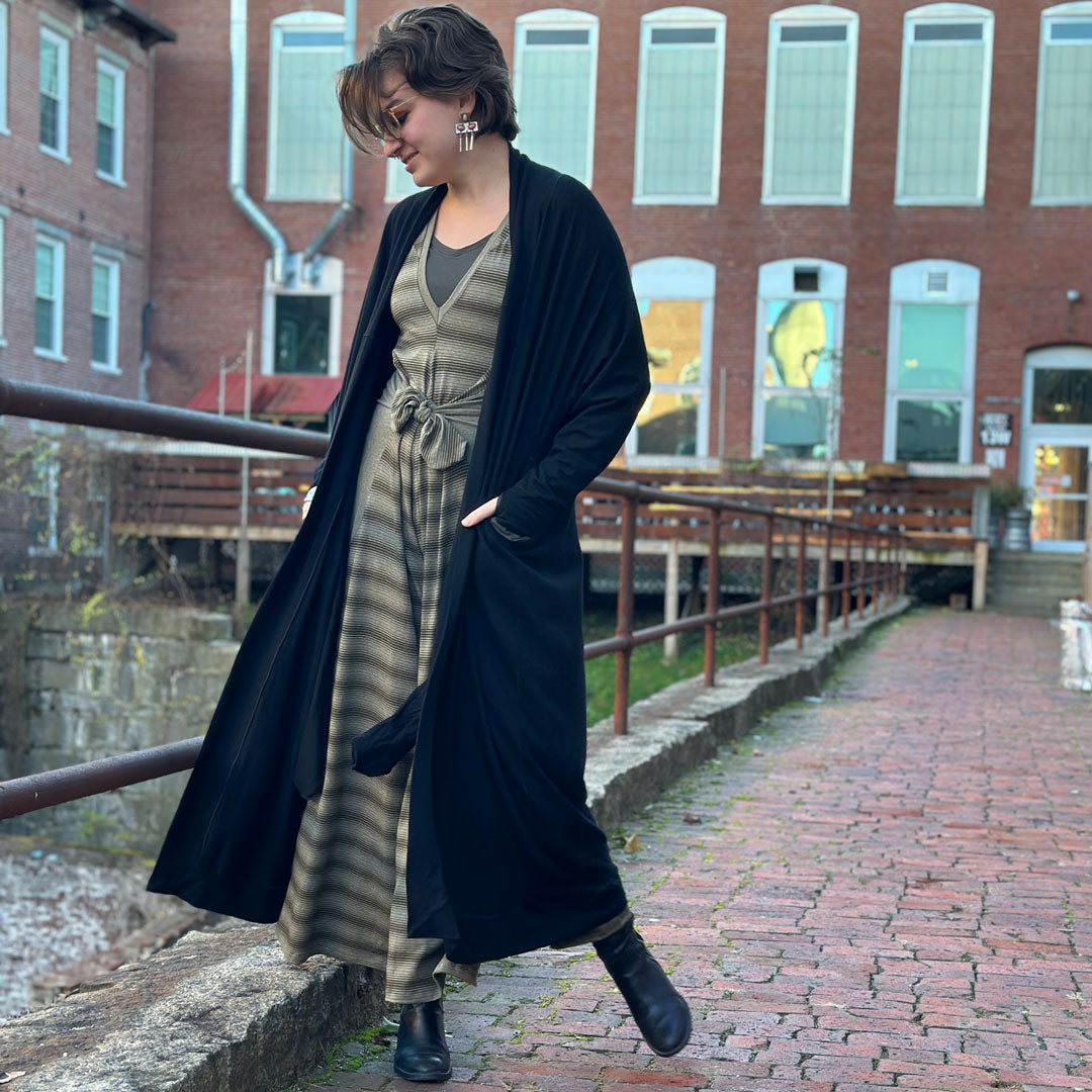 suger farmer jumpsuit in country sage paired with a black duster sweater