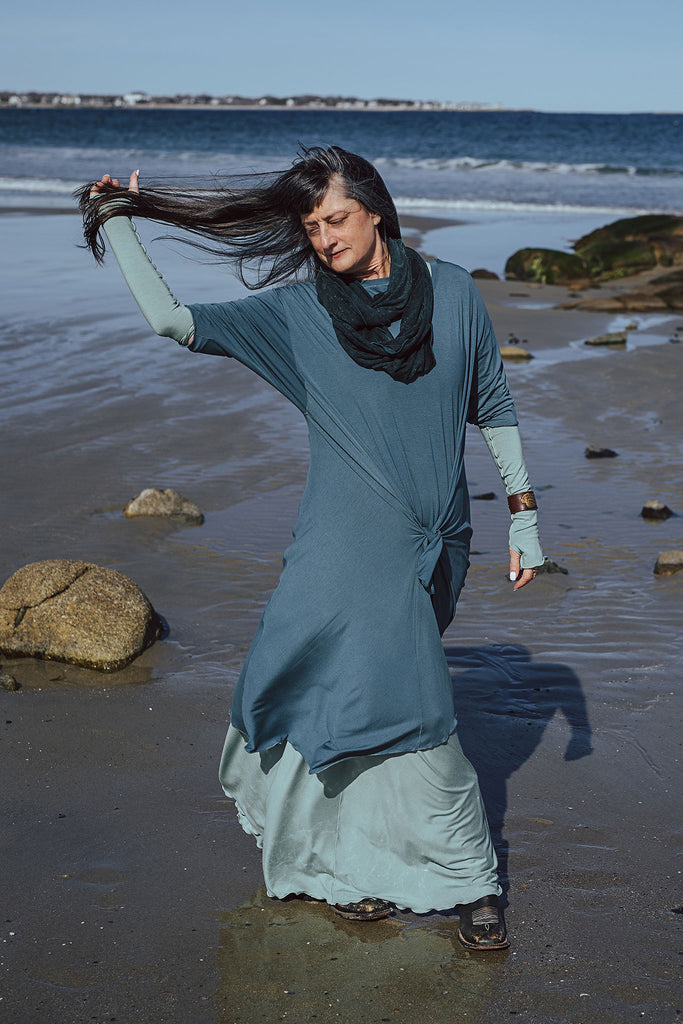 angelrox® loop scarf in blue mineral styled with glass glow down with ocean tide over it