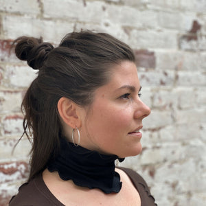 peat band secures top knot with second black band at neck