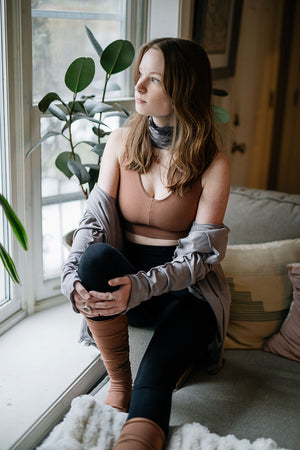 balance bra in cedar paired with cardi jacket in moon, black playsuit, and cedar stockings