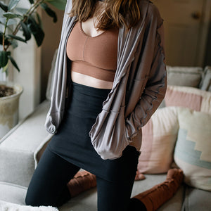 playsuit in black with top section folded over into a skirt; paired with cardi jacket in moon, cedar balance bra, and cedar stockings