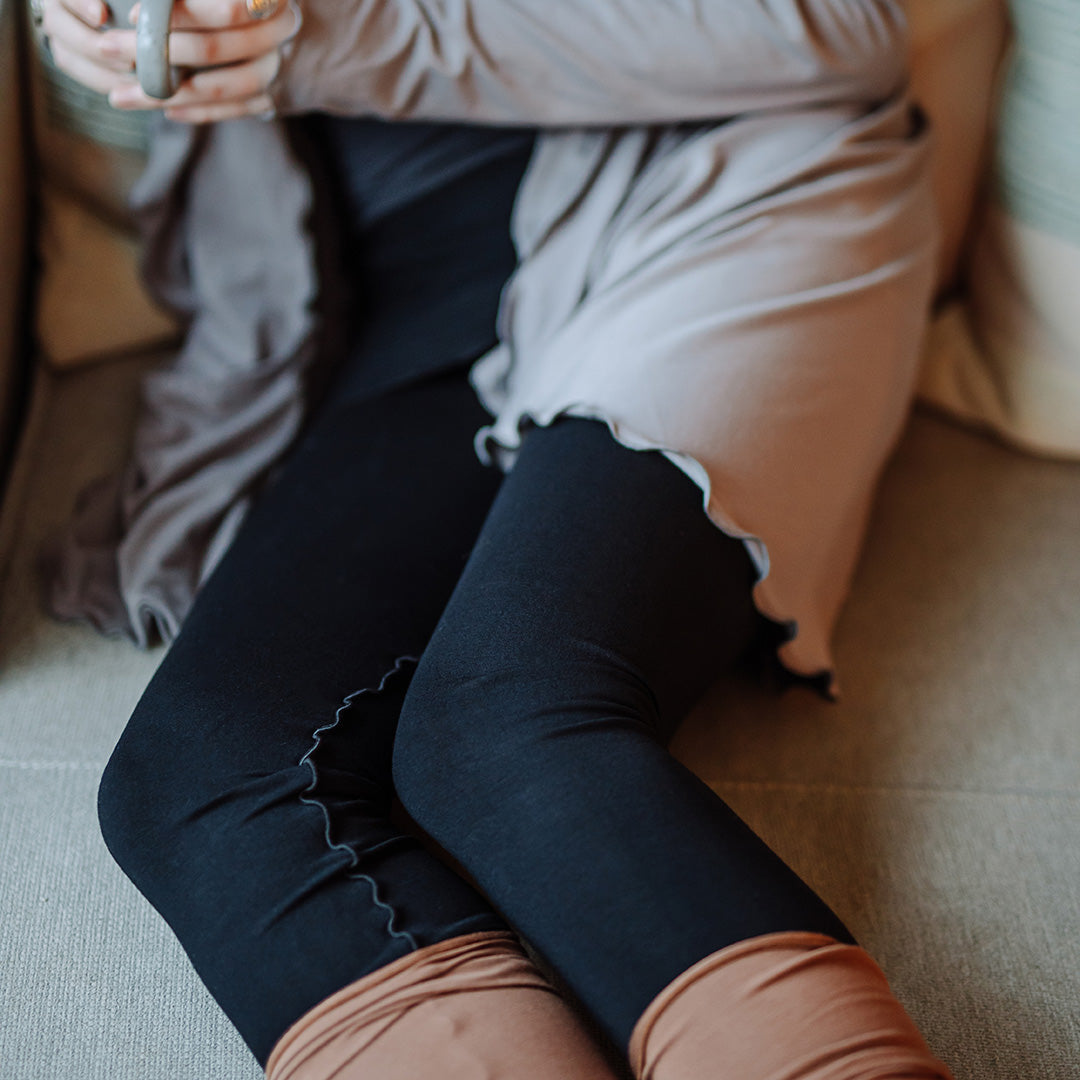 playsuit in black with top section folded over into a skirt; paired with cardi jacket in moon, cedar stockings, and core tank in carbon