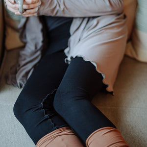 playsuit in black with top section folded over into a skirt; paired with cardi jacket in moon, cedar stockings, and core tank in carbon