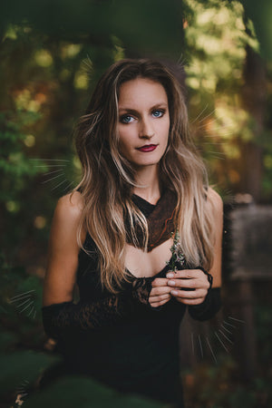 goddess dress in subtle black with black lace opera sleeves and spice mineral hourglass at neck