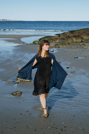 shawl in navy worn over glow dress in mineral