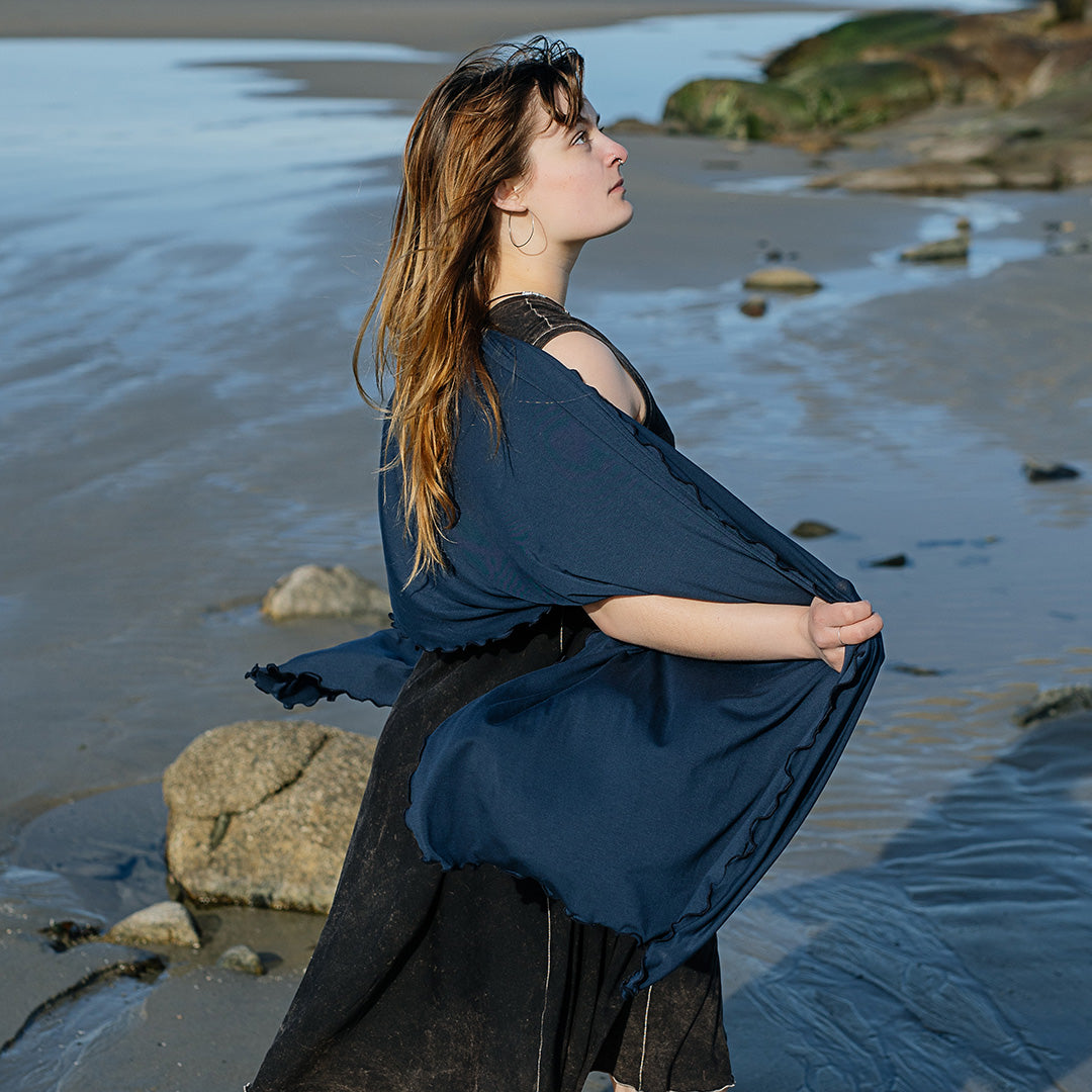 shawl in navy worn over glow dress in mineral