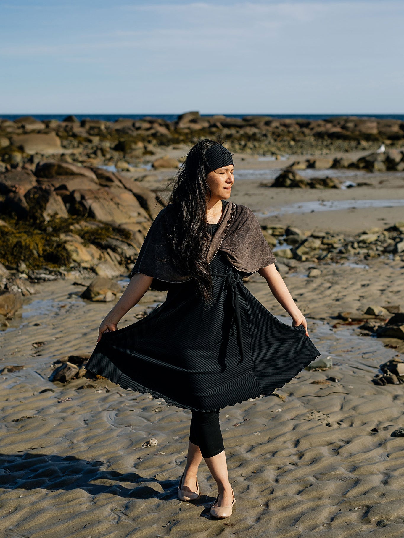glow dress in subtle black with loop in warm mineral worn as a shawl