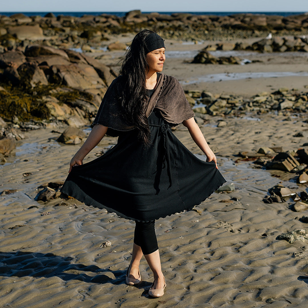 glow dress in subtle black worn with loop in warm mineral worn as a shawl
