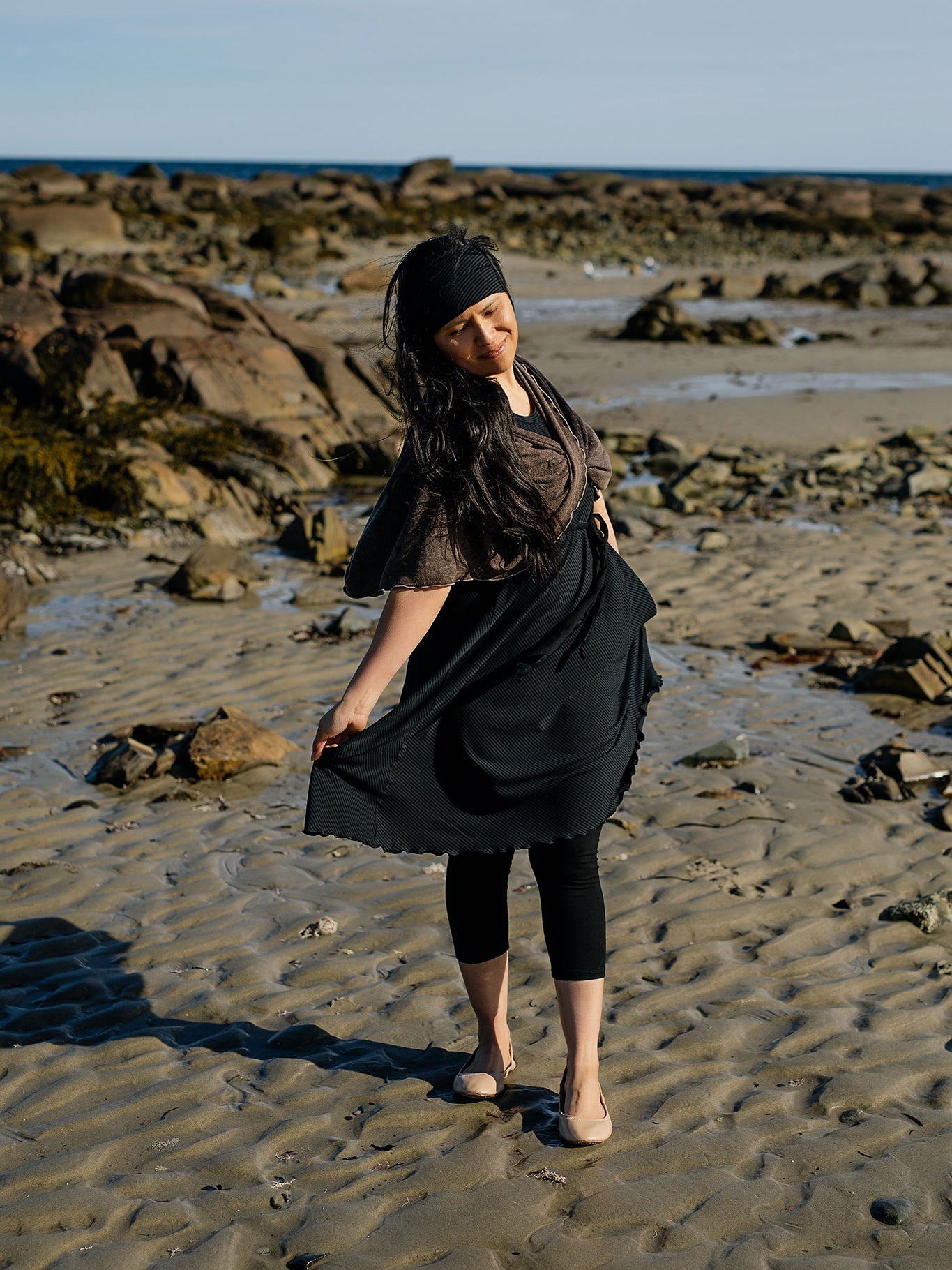 glow dress in subtle black with loop in warm mineral worn as a shawl
