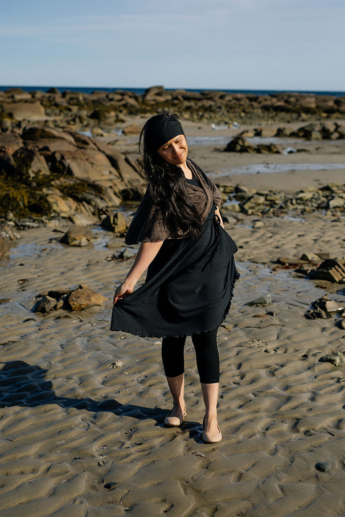 glow dress in subtle black with loop in warm mineral worn as a shawl
