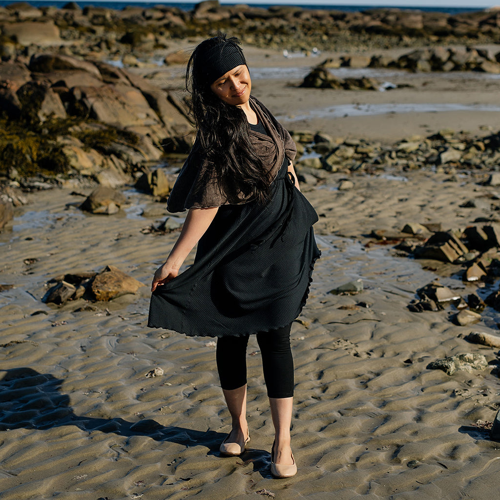 glow dress in subtle black worn with loop in warm mineral worn as a shawl