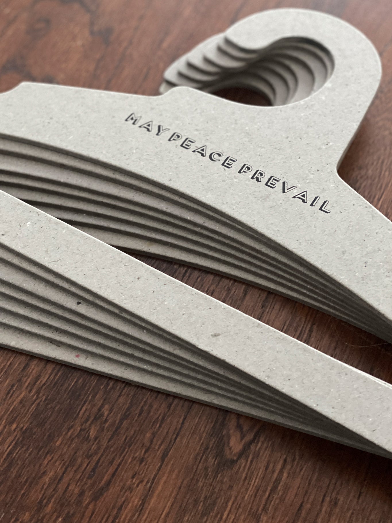 Perchas de cartón reciclado con la palabra paz