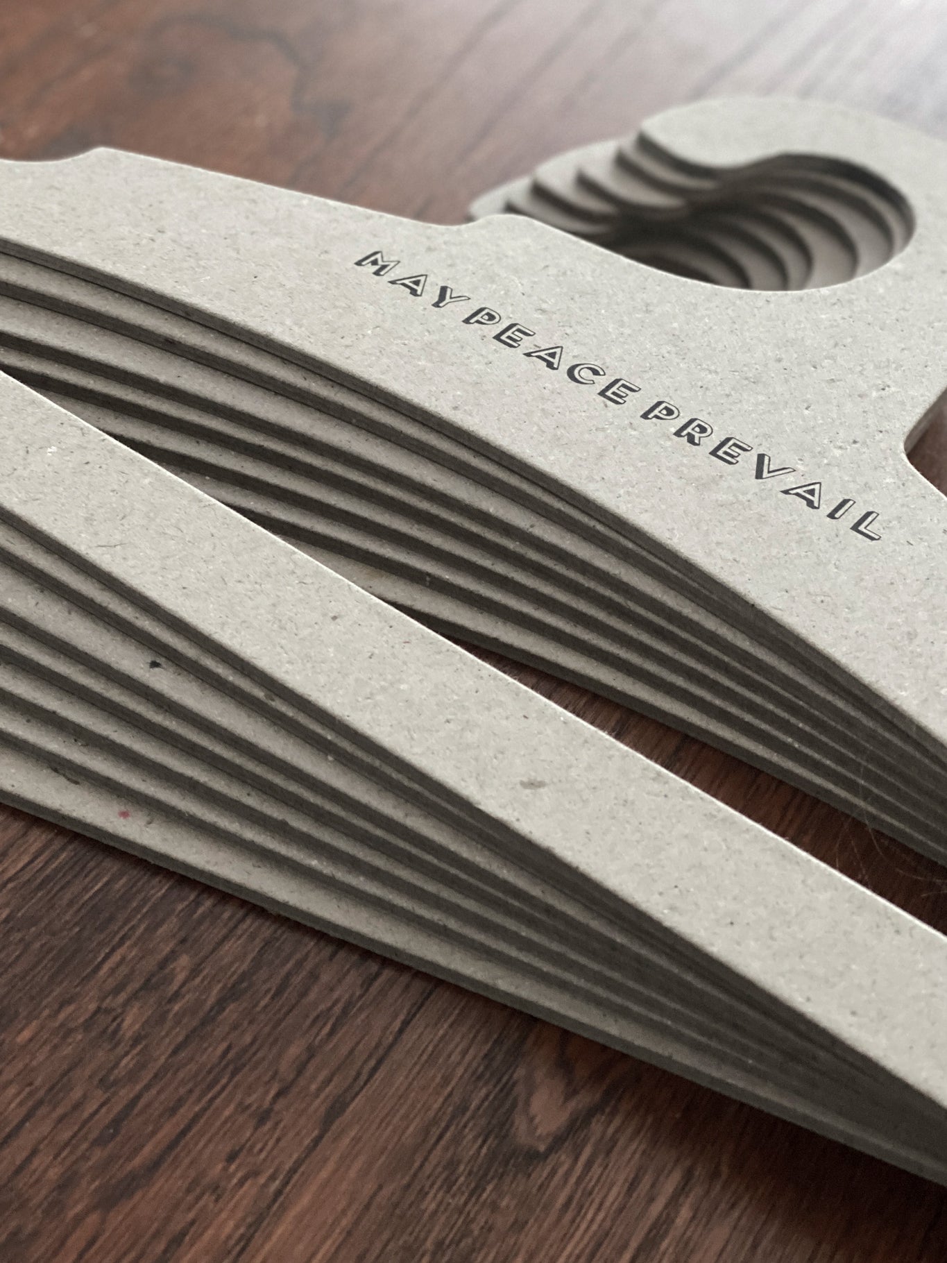 Perchas de cartón reciclado con la palabra paz