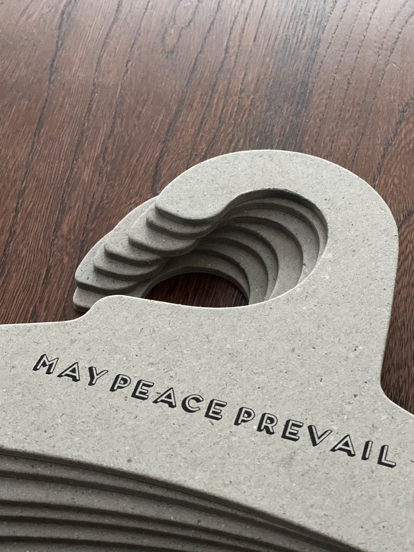 Perchas de cartón reciclado con la palabra paz