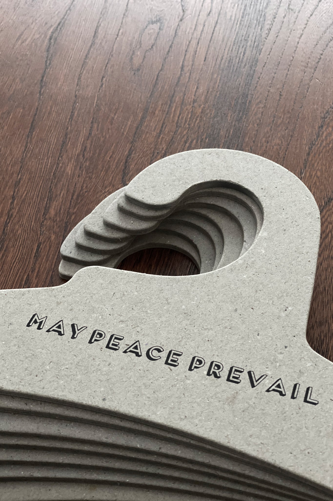 Perchas de cartón reciclado con la palabra paz