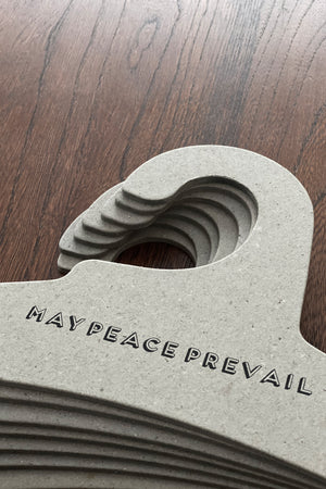 Perchas de cartón reciclado con la palabra paz