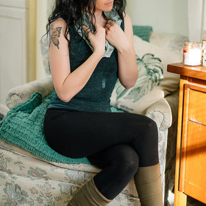 base legging in black paired with blue mineral core tank, glass hourglass around neck, and olive stocking