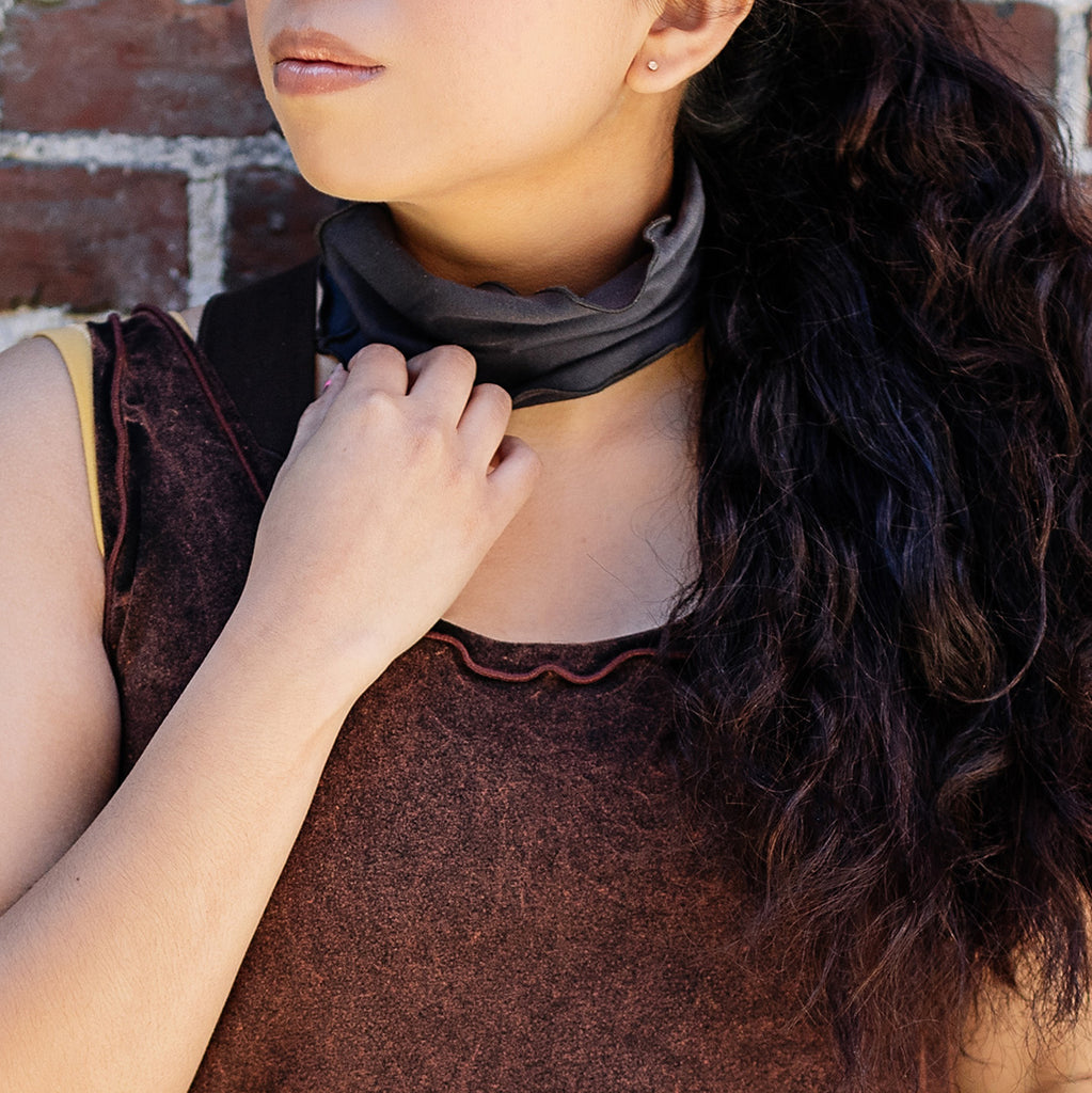the band in carbon worn around the neck, paired with lush mineral shift tunic