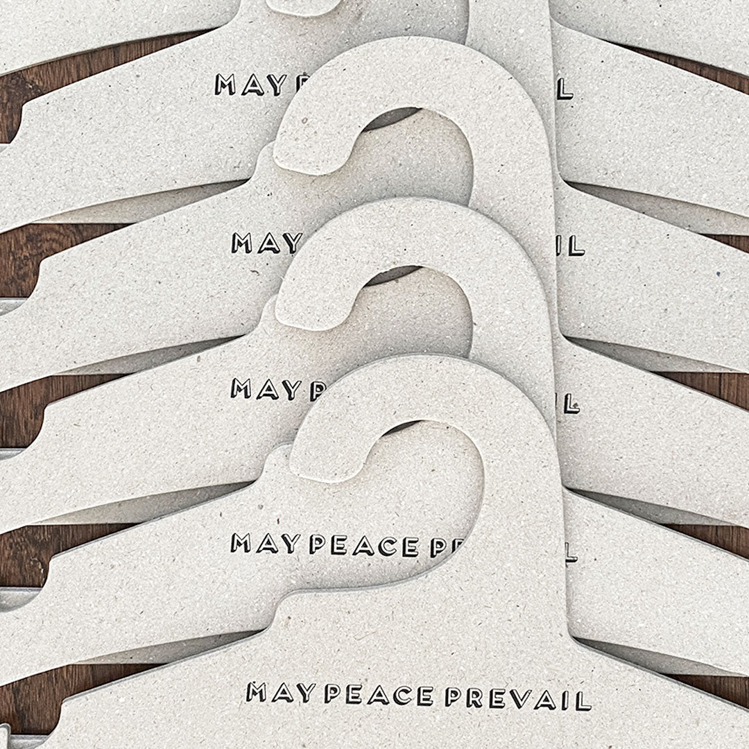 Perchas de cartón reciclado con la palabra paz