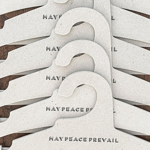 Perchas de cartón reciclado con la palabra paz