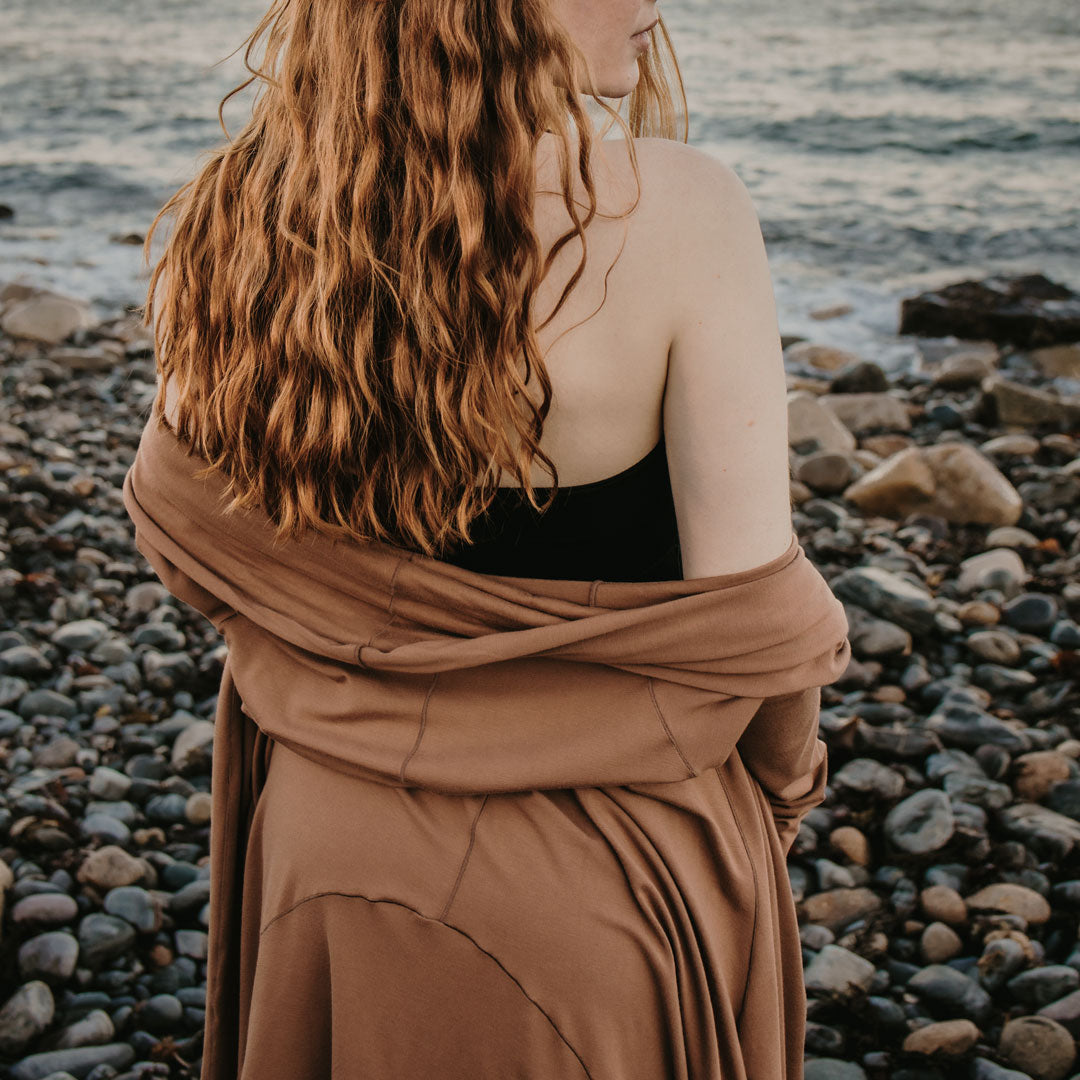 cedar riding coat on pebbled beach