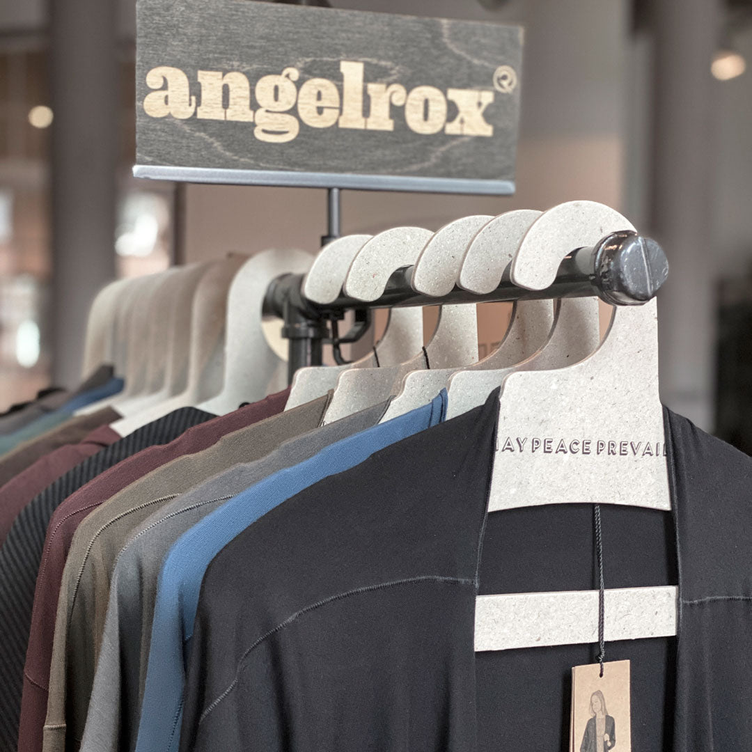 Perchas de cartón reciclado con la palabra paz