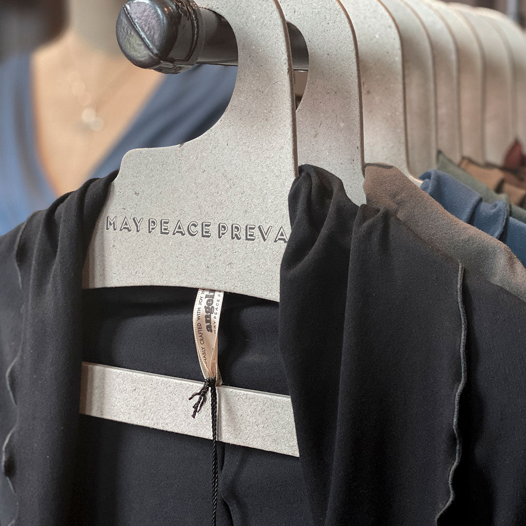 Perchas de cartón reciclado con la palabra paz