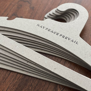 Perchas de cartón reciclado con la palabra paz