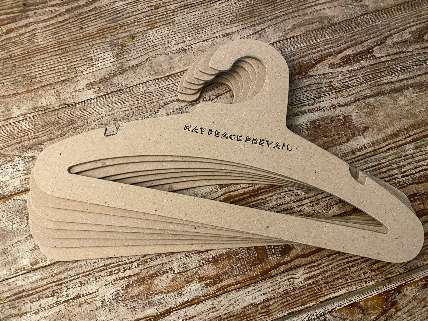 Perchas de cartón reciclado con la palabra paz