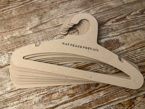 Perchas de cartón reciclado con la palabra paz